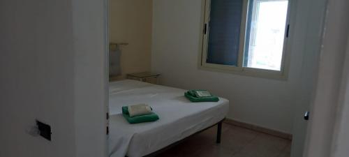 1 dormitorio con 1 cama con 2 almohadas verdes en Villa Ipanema, en Salve