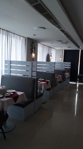 a dining room with tables and chairs in a restaurant at Savoy Grand Hotel Apartments in Muscat