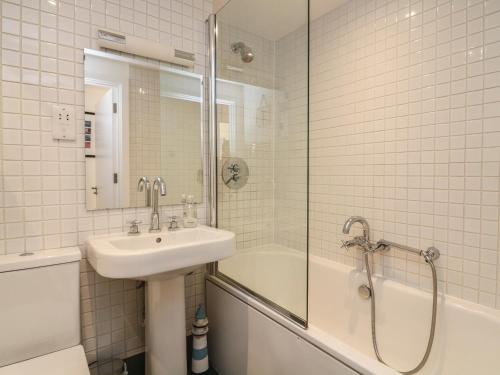 a bathroom with a sink and a tub and a shower at 5 Combehaven in Salcombe