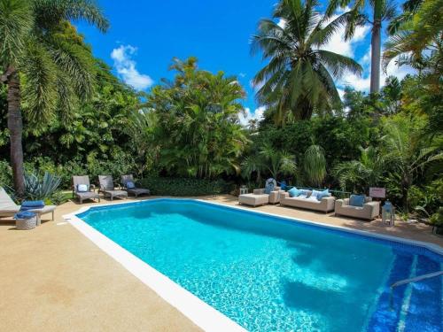 a swimming pool with chairs and palm trees at Amazing Villa with Pool 5 mins from Beach - Palm Grove 1 home in Saint Peter