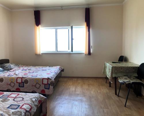 a room with two beds and a window at Guest House Issyk-Kul Nomad in Bosteri