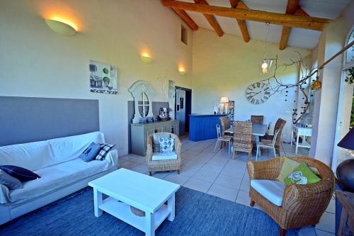 ein Wohnzimmer mit einem Sofa und einem Tisch in der Unterkunft Gîte Crillon - Mas Les Fleurs d'Hilaire in Monteux