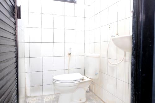 Hotel Puri Lembang near Universitas Sulawesi Barat Majene في Lutan: حمام ابيض مع مرحاض ومغسلة