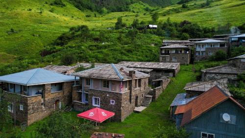 an aerial view of a village with houses and a hill at Guest House Temi In Gudani 