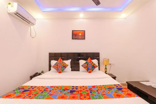 a bedroom with a bed with a colorful comforter at FabExpress Elite Inn in Patna