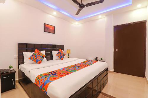 sypialnia z dużym łóżkiem z kolorowymi poduszkami w obiekcie FabExpress Elite Inn w mieście Patna