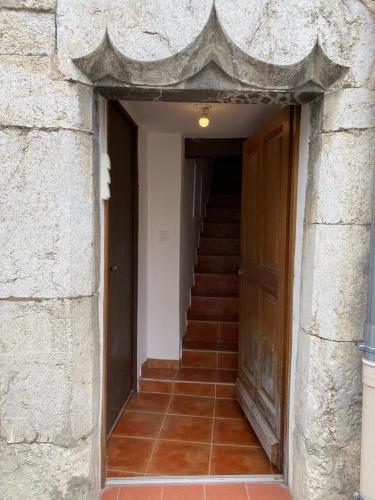 una entrada a un edificio con una puerta y escaleras en petit appartement calme en plein centre du village de ribiers, en Ribiers