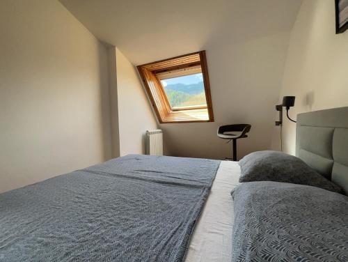um quarto com uma cama grande e uma janela em La Vita em Ravascletto