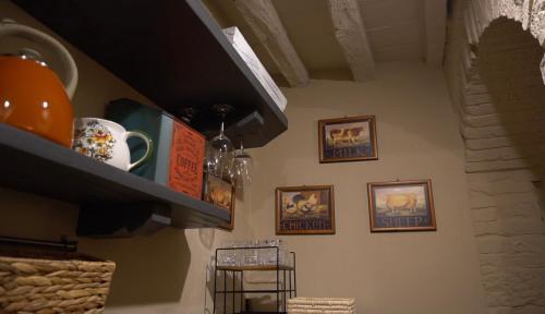 a shelf in a kitchen with pictures of animals on the wall at Oberdan Ospitalita' in Todi