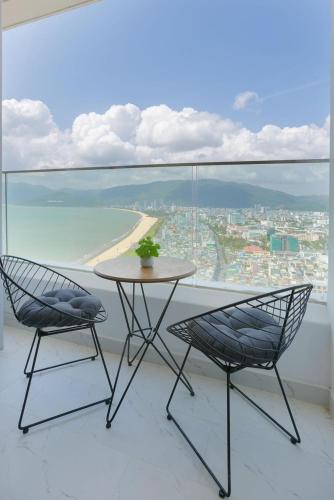 einen Tisch und Stühle auf einem Balkon mit Blick auf den Strand in der Unterkunft Căn hộ minhon in Quy Nhon