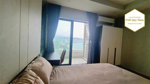 ein Schlafzimmer mit einem Bett und einem großen Fenster in der Unterkunft Căn hộ minhon in Quy Nhon