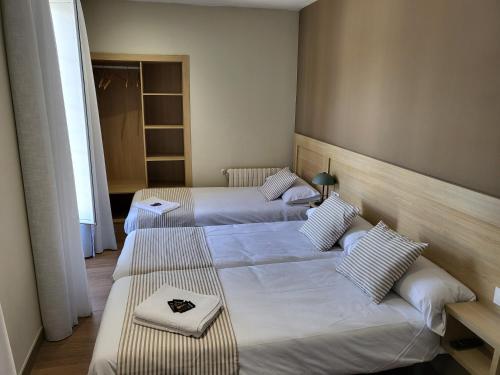 um quarto com três camas num quarto em CASA MARUXA pensión em Pontevedra