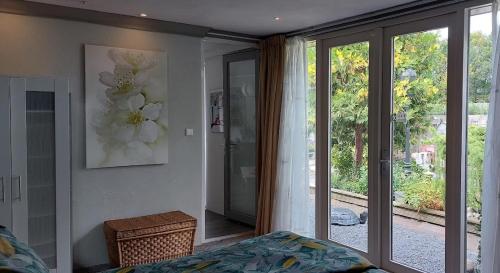 Schlafzimmer mit einem Bett und einer Glasschiebetür in der Unterkunft HOME for 2 in Zuidoostbeemster