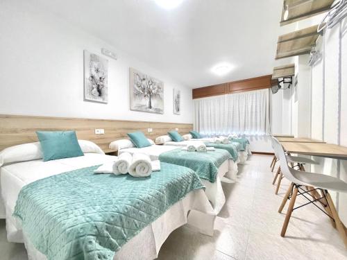 a room with a row of beds with towels on them at Pension O Camiño Milladoiro in Amés