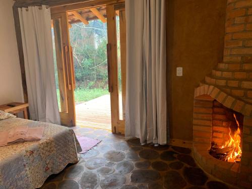 a bedroom with a fireplace and a bed in a room at Chalés Sítio Do Tanque in Conceição da Ibitipoca