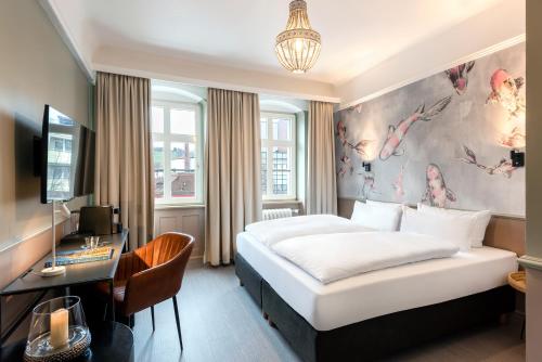 a hotel room with a bed and a desk at Hotel Würzburger Hof **** in Würzburg