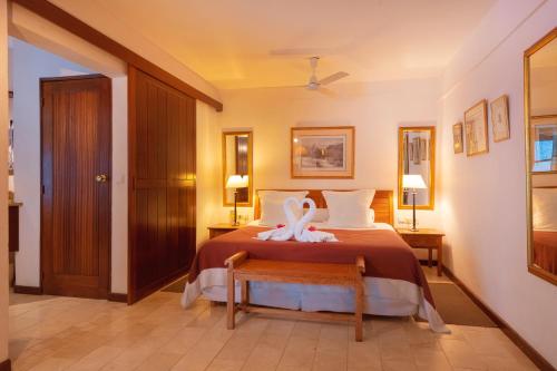 a bedroom with a bed with a towel on it at Le Saint Alexis **** Hotel & Spa in Saint-Gilles les Bains
