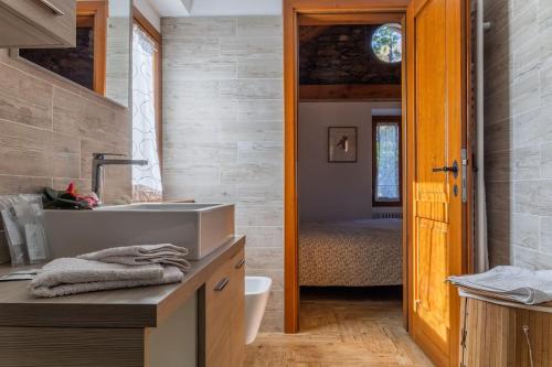 a bathroom with a sink and a bedroom with a bed at La Camelia d'Oro in Oggebbio