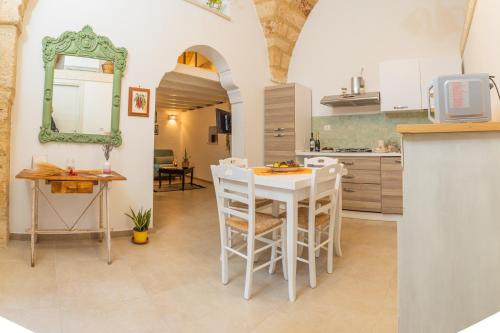 a kitchen and dining room with a white table and chairs at Casa Taila in Ruffano