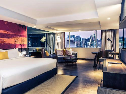 バンコクにあるMercure Bangkok Sukhumvit 11のベッド付きのホテルルームで、市街の景色を望めます。