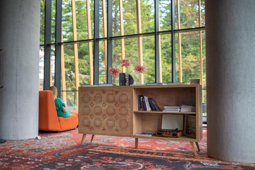 a living room with a book shelf and a large window at Hotel Nomad in Bjelašnica