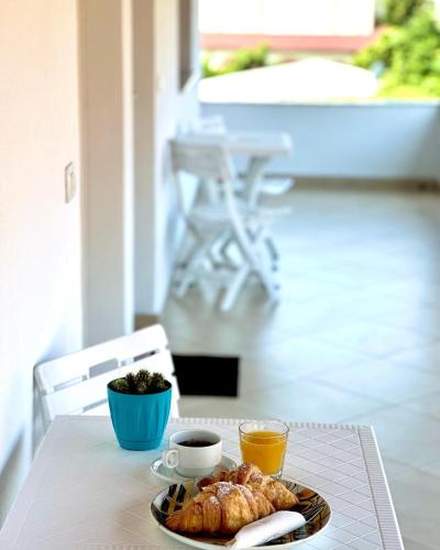 a table with a plate of pastries and cups of coffee at Js House Shkoder 1 in Shkodër