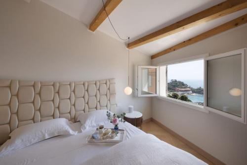 une chambre avec un grand lit blanc avec une fenêtre dans l'établissement La Clubhouse, Monaco Country Club, à Roquebrune-Cap-Martin