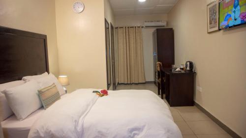 a bedroom with a white bed with a flower on it at SSNIT GUEST HOUSE in Nima