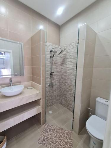 a bathroom with a shower and a sink and a toilet at Appartement Sable blanc in Al Hoceïma