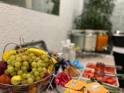 a basket of grapes and other fruits on a kitchen counter at Elizeu Hotel in Bucharest