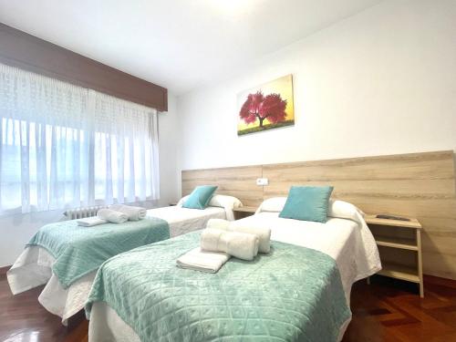 a hospital room with two beds and a window at Pension O Camiño Milladoiro in Amés
