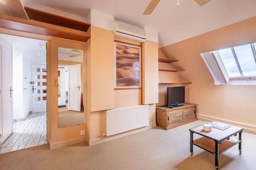 un salon avec une télévision et une table dans l'établissement Le Concorde en plein centre, à Amboise