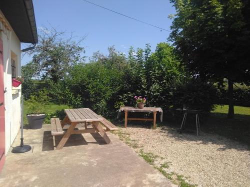 un tavolo da picnic e una panca in legno in un cortile di Grande Maison de plain pied avec jardin arboré. a Champignelles