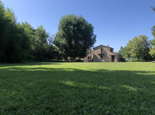 a large field of grass with a house in the background at Le Case Resort in Macerata