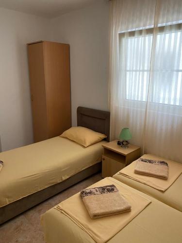 two beds in a small room with a window at Vila Zara in Donji Štoj