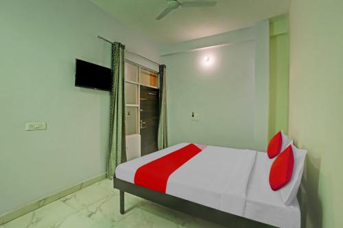 een slaapkamer met een bed met rode kussens erop bij OYO Flagship Hotel Arya Residency in Gurgaon