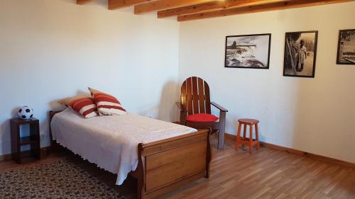 a bedroom with a bed and a chair at Casa Luciana in Ponta do Pargo