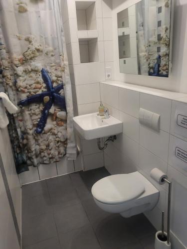 een badkamer met een toilet, een wastafel en een douchegordijn bij Atelier Zille A66 - Nähe Alexanderplatz in Berlijn