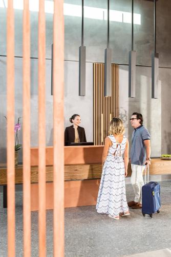 a man and a woman with a suitcase and a man at Pilot Amphora Boutique Hotel "Adults Only" in Georgioupolis