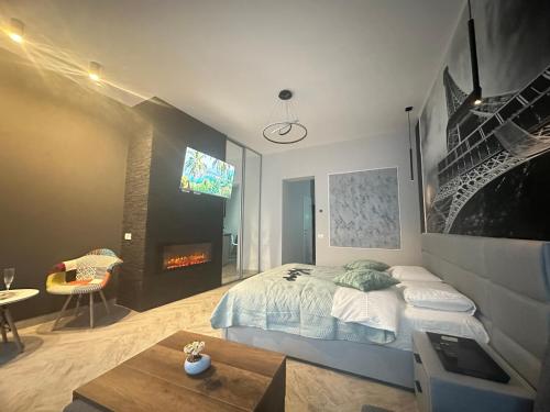 ブラショヴにあるStay Inn Central Brasov Apartmentsのベッドルーム(ベッド1台、テレビ、テーブル付)