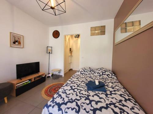 une chambre avec un lit et une télévision à écran plat dans l'établissement Cosy Studio à Cannes 8 min de la Croisette, à Cannes
