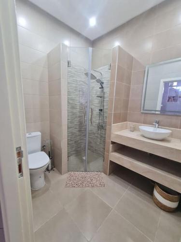 uma casa de banho com um chuveiro, um WC e um lavatório. em Appartement Sable Rose em Al Hoceïma