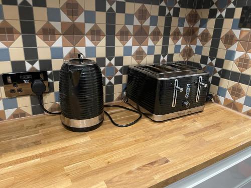 a counter with two toasters and a toaster on it at Modern 4-bedroom entire house with Garden in Uxbridge