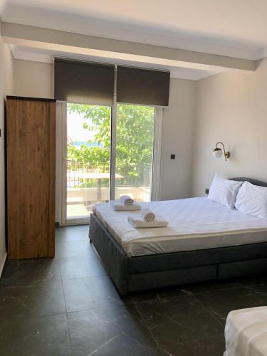 a bedroom with a large bed and a large window at Tangiers Hotel Ex Marina Bay in Bodrum City