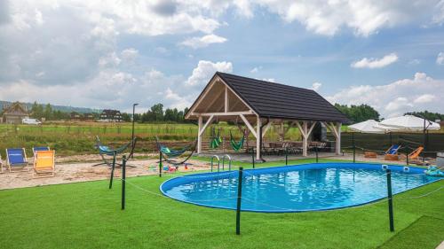 a swimming pool with a gazebo and a playground at Apartamenty Sun & Snow Resorts L Białka Tatrzańska z sauną in Białka Tatrzańska