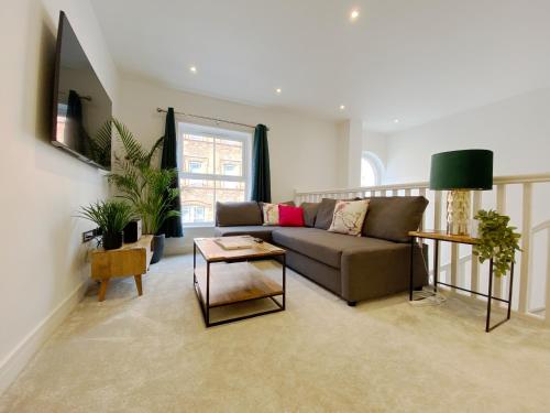 a living room with a couch and a table at The Seaside Maisonette. Free Parking/Close To Town in Bournemouth