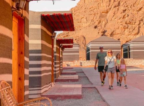 a man and a woman walking down a street at Wadi Rum Aviva camp in Wadi Rum