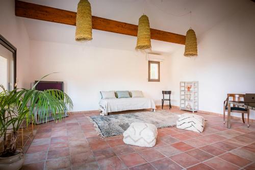 een woonkamer met een bed en een tafel bij La Pampa de Fressac, maison dans un cadre unique in Fressac