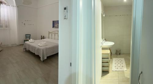 a bedroom with a bed and a sink in a room at Apulia Rooms in Taranto