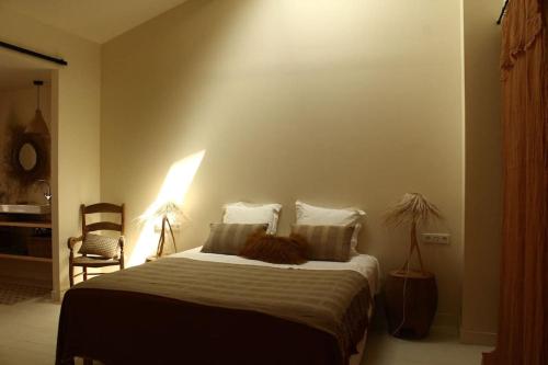 a bedroom with a bed with a lamp and a chair at Loft Augustine in Leucate